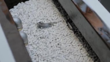 Aşındırıcı taşlarla metal işçilikleri parlatan bir vibratör makinesi.