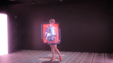 AR sergisinde 3D büyük hologram projeksiyonuyla poz veren kadın