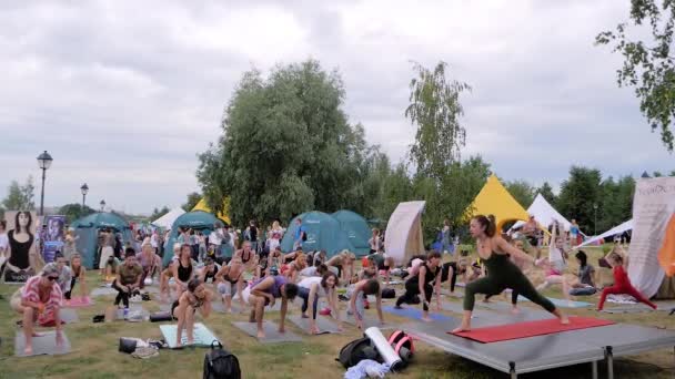 Gruppo di persone con allenatore che fanno esercizi di yoga nella foresta - rallentatore — Video Stock