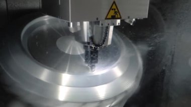 Fabrikada metal işçiliği kesen soğutma sistemi olan bir değirmen makinesi.