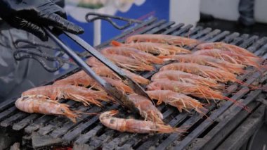 Şef taze kırmızı kral karidesleri mangalda pişirecek.