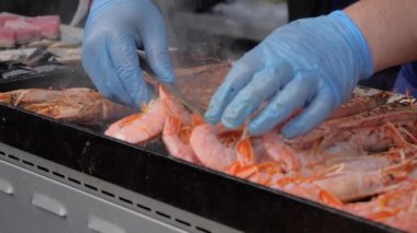 Yavaş çekim: şef yaz yerel yemeklerinde ızgarada taze kırmızı langoustine pişiriyor.