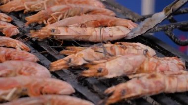 Yavaş çekim: Şef Brezilya usulü taze karides ızgara yapıyor.