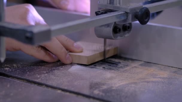 Movimento lento: carpinteiro usando ferramenta de serra de fita, corte de pedaço de madeira - close-up — Vídeo de Stock