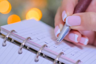 Defterde yapılacaklar listesine işaret koyan kadın - kapat