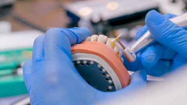 Diş teknisyeni diş protezleriyle çalışıyor. Görüntüyü kapat.