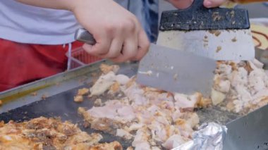Yavaş çekim: şef sokak yemekleri festivalinde ızgara tavuk eti kesiyor