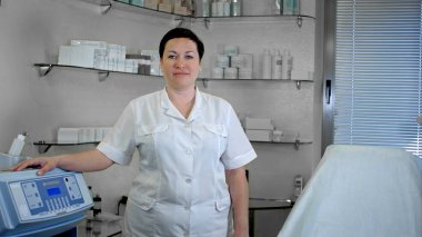 Laboratuvar önlüğü içinde ayakta, kameraya bakarak kendine güvenen kadın doktor portresi