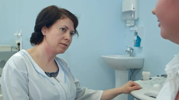 Досвідчена жінка-лікар розмовляє з пацієнтом у лікарні — стокове фото