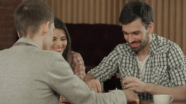 Друзья отдыхают в кафе и играют в шахматы — стоковое фото