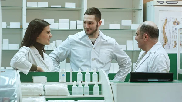 Équipe de pharmacien chimiste femme et homme debout dans la pharmacie pharmacie et parler positif — Photo