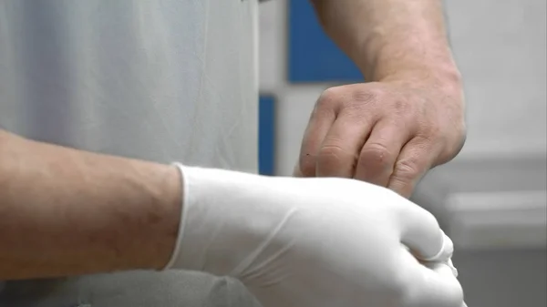 Dokter memakai sarung tangan bedah yang disterilkan putih — Stok Foto
