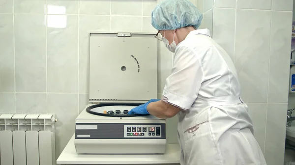 Enfermeira colocando tubos de sangue no laboratório centrífuga — Fotografia de Stock