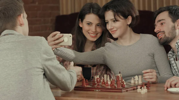 Gruppe von Studenten beim Schachspielen, während sie Selfie-Fotos machen — Stockfoto