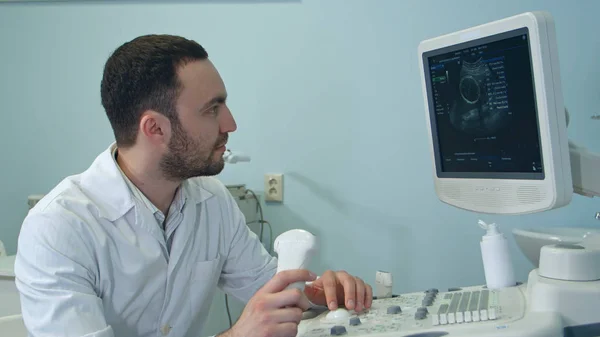 Erkek doktor ultrason taraması sonuçlarına bakarak konsantre — Stok fotoğraf