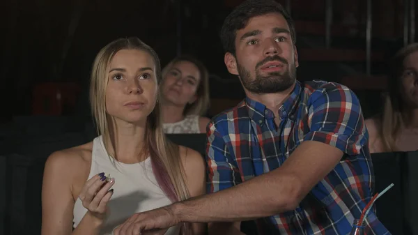 Pareja feliz sentada en el cine, comiendo palomitas, sonriendo — Foto de Stock