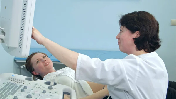 Leende gravid kvinna tittar på ultraljud resultat med läkare — Stockfoto