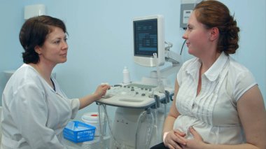 Mutlu hamile kadın gülümseyen kadın doktor için söz