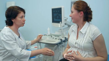 Kadın doktor tıbbi prosedür için gelecekte anne açıklayan