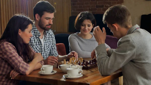 Студенты играют в шахматы в кафе — стоковое фото