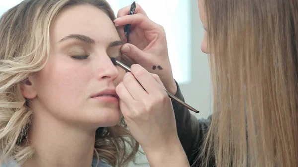 Make-up artist applying eyelash makeup to model eye — Stock Photo, Image