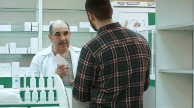 Genç erkek müşteri eczacı, eczane blister hap almak
