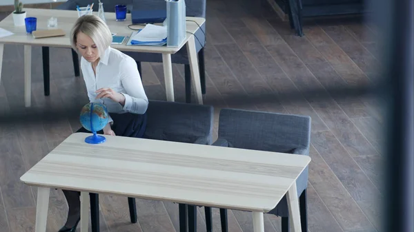 Femme d'affaires blonde regardant globe dans le bureau — Photo