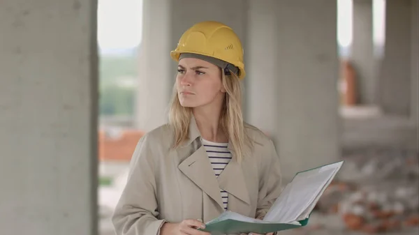 Engenheira está irritada e chateada lendo o plano de construção — Fotografia de Stock