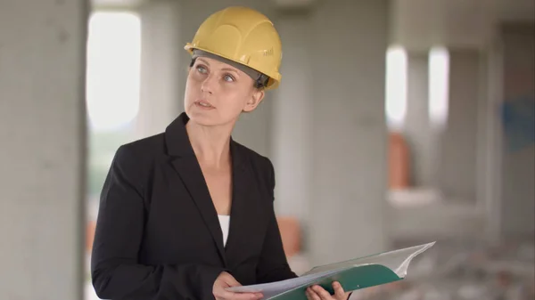 Architecte féminine regardant les plans sur le chantier de construction — Photo