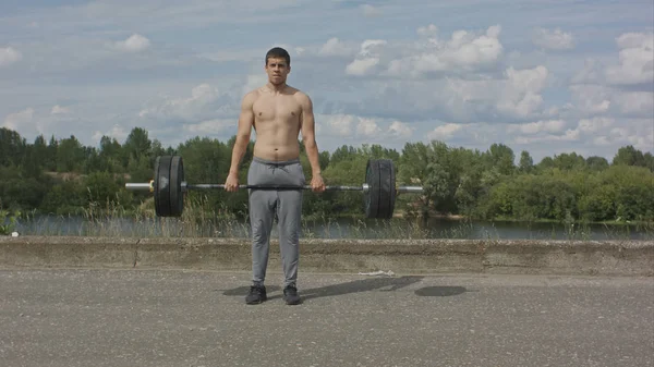 Culturista haciendo ejercicio de pesas con barra de pesas deadlift con barra pesada —  Fotos de Stock