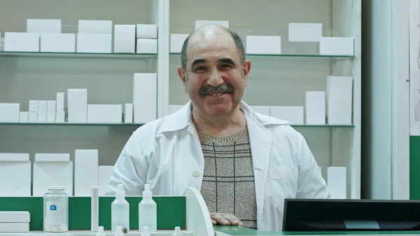 Retrato de farmacêutico sênior sorrindo e conversando com uma câmera — Fotografia de Stock