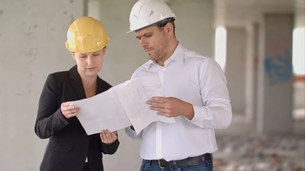 Architektenteam Mann und Frau diskutieren über Bauplan für Baustelle — Stockfoto