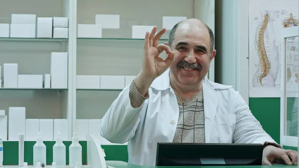 Щасливий чоловік фармацевт показує правильний знак і пахне посмішкою — стокове фото