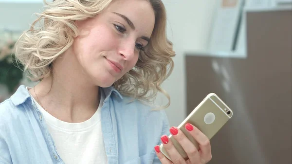 Mujer joven pensativa usar el teléfono celular en el salón por la mañana — Foto de Stock