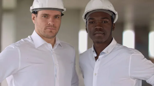 Dois engenheiros, um caucasiano e um afro-americano, posando olhando para a câmera — Fotografia de Stock