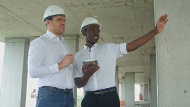 Üst düzey yönetim ekibi ile tablet resmi giyimli insanlar inşaat tablet binanın önünde okuma gözden inşaat sitesinde