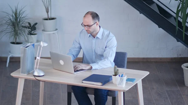 Красивий бізнесмен працює з ноутбуком в офісі — стокове фото