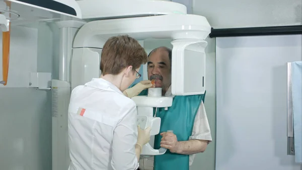 医師や放射線技師のコンピューターをしている年配の男性を助けることを歯の分析します。 — ストック写真