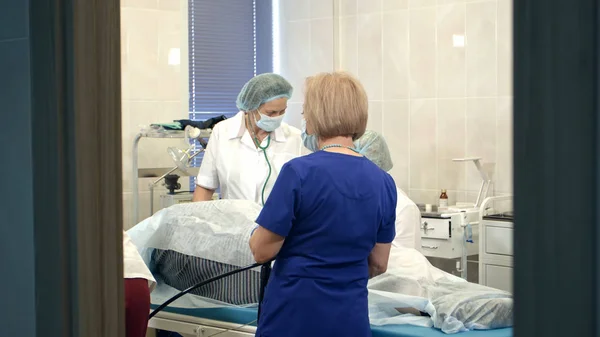 Médicos gerenciando endoscópio moderno durante o procedimento médico no hospital — Fotografia de Stock