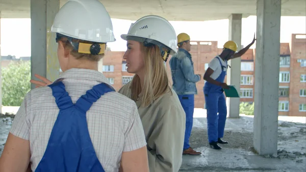 Ung arkitektur och kvinnlig arbetstagare talar på öppet lufta byggarbetsplats — Stockfoto
