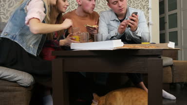 Aç kedi masanın altında insanlar yemek iken