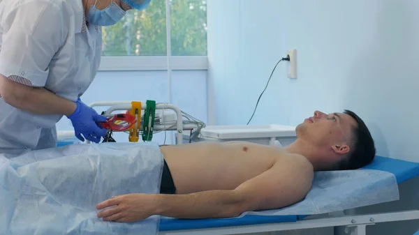 Enfermeira preparando paciente do sexo masculino para o teste de ECG — Fotografia de Stock