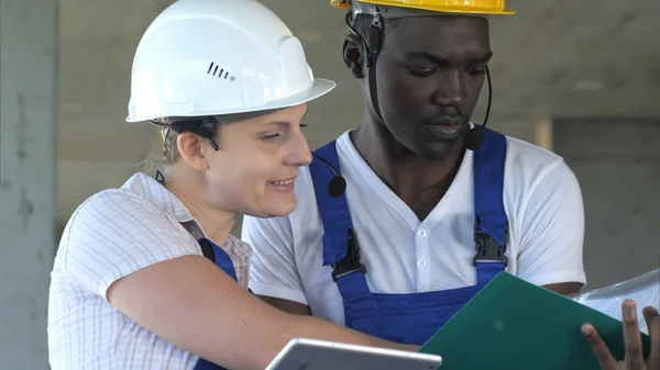 Two workers having conversation and using tablet computer