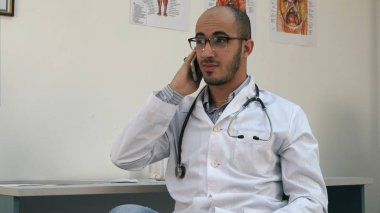 Gülümseyen erkek doktor neşeli telefon sohbet ediyor. Lumix Gh4 profesyonel vuruşta 4 k çözünürlüklü. Örneğin, reklam videosu, iş, tanıtım, tıbbi, yayın kullanabilmeniz için