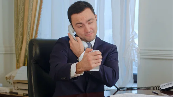 Hombre de negocios exitoso tomando un selfies divertido por su teléfono inteligente y luego tener una llamada de teléfono fijo — Foto de Stock