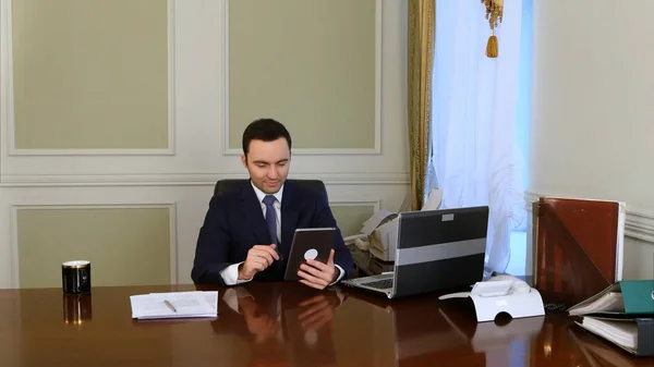 Empresario trabajando en tableta y sonriendo — Foto de Stock