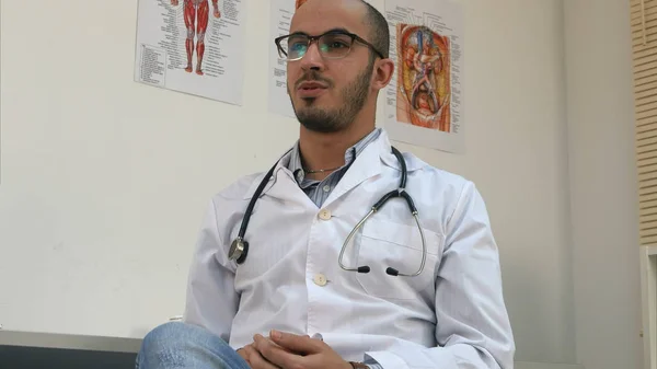 Positive male doctor in office talking to patient — Stock Photo, Image