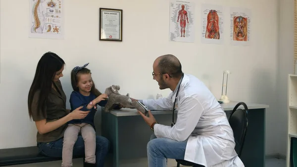 動揺の小さい女の子の患者を応援するためウサギのおもちゃを与える笑顔の医者 — ストック写真