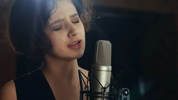 Schöne Mädchen singt in ein Mikrofon in Café — Stockfoto