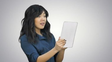 Asya iş kadını beyaz arka plan üzerinde bir tablet kullanarak sohbet
